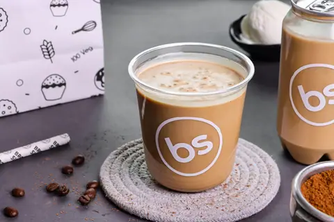 Iced coffee in a clear cup with Brown Sugar logo on a coaster