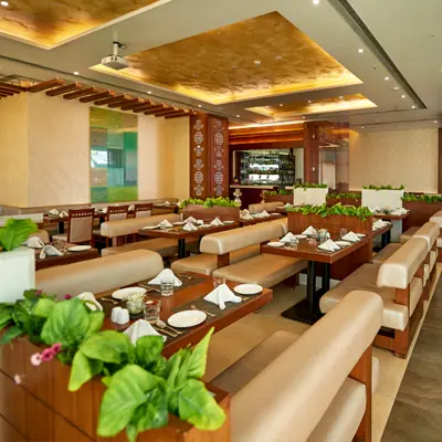 Spacious dining area with beige seating and wooden tables at Yellow Chilli Pune