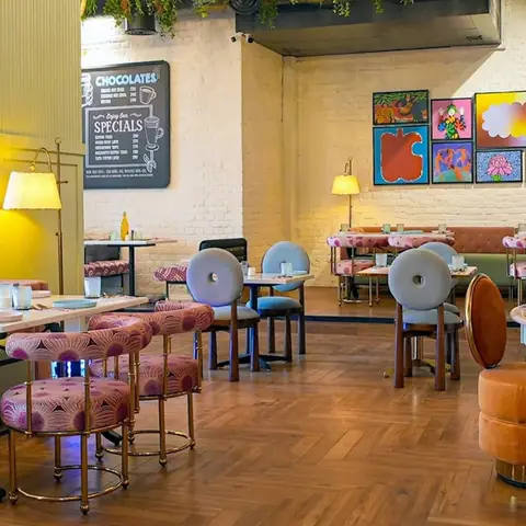 Seating area with colorful chairs and wall art in a cozy restaurant