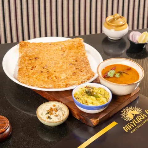 Crispy dosa served with sambar, chutney, and vegetable side dish