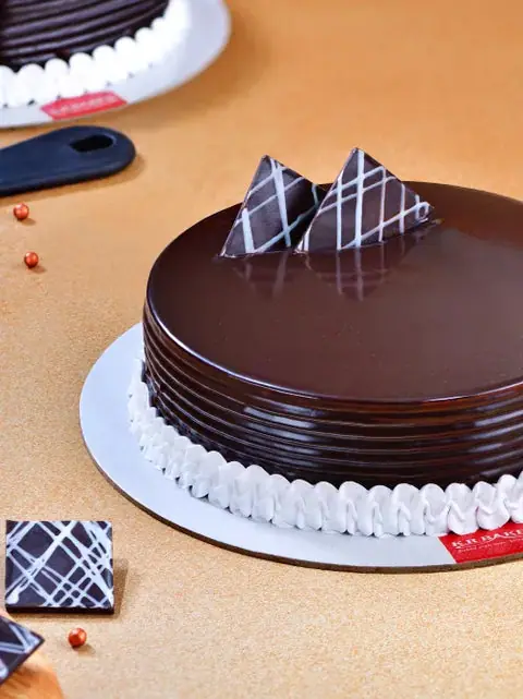 Chocolate cake with white cream border and chocolate decorations