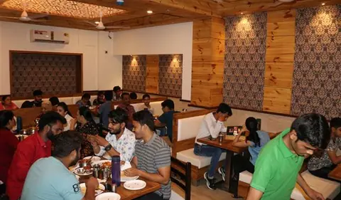 Dining area with wooden decor and customers eating at Bawarchi Restaurant