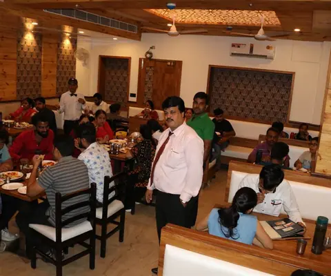 Dining area with customers and staff inside Bawarchi Restaurant, Udaipur