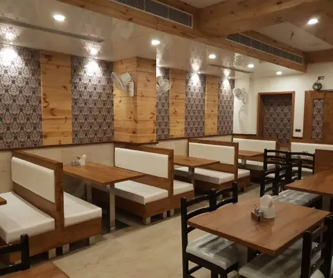 Wood-paneled dining area with cushioned benches and wooden tables