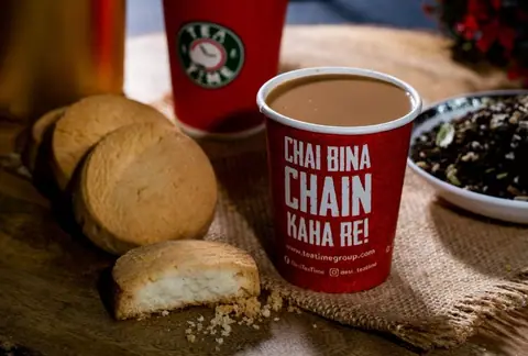 Cup of chai tea with biscuits on a wooden surface